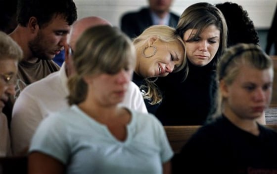 Sisters Brittany, left, and Kristen Bridges both former students at Memphis Junior Academy weep during an impromptu prayer vigil for slain principal Suzette York, who was killed in August 2011 in one of the school's classrooms in Memphis, Tenn.